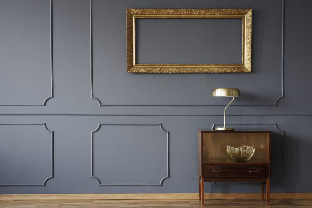 wall with decorative molding painted to match gray wall