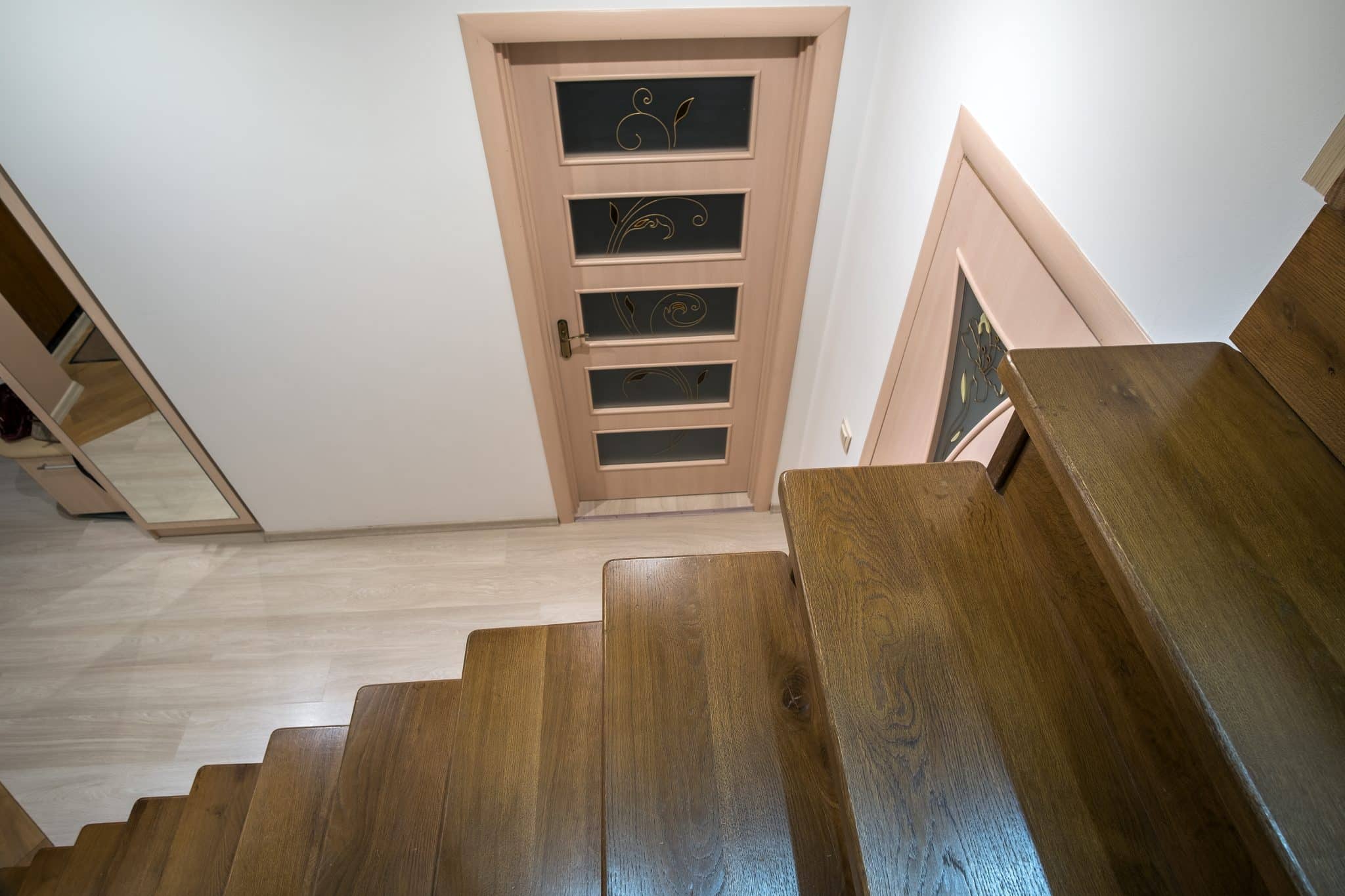 A light color wood floor stain while the stairs are stained a darker color